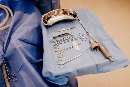 Sterile Processing Technician Jobs No Experience: How Hospitals Can Build an Entry-Level SPD Pipeline 2 A set of surgical instruments arranged on a blue drape in a sterile operating room setting.